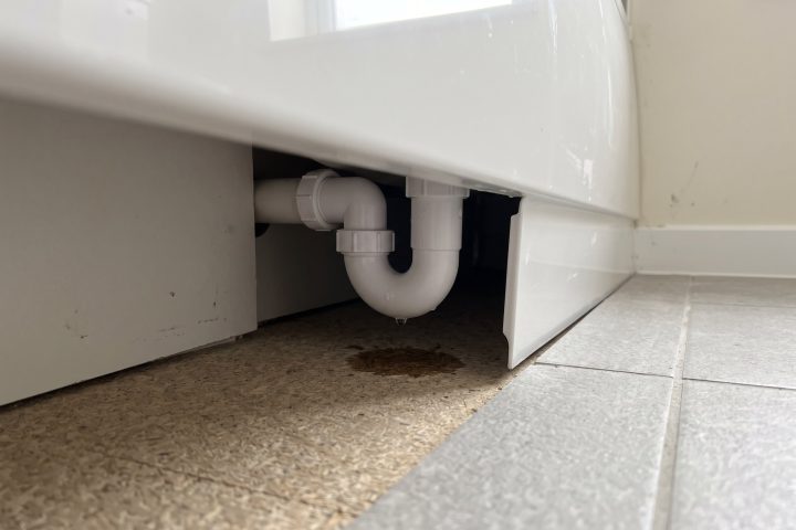 Unsealed bath panel with a weeping waste trap behind it