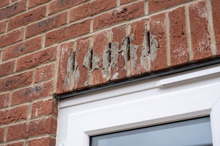 Weep holes above a patio door blocked with mortar