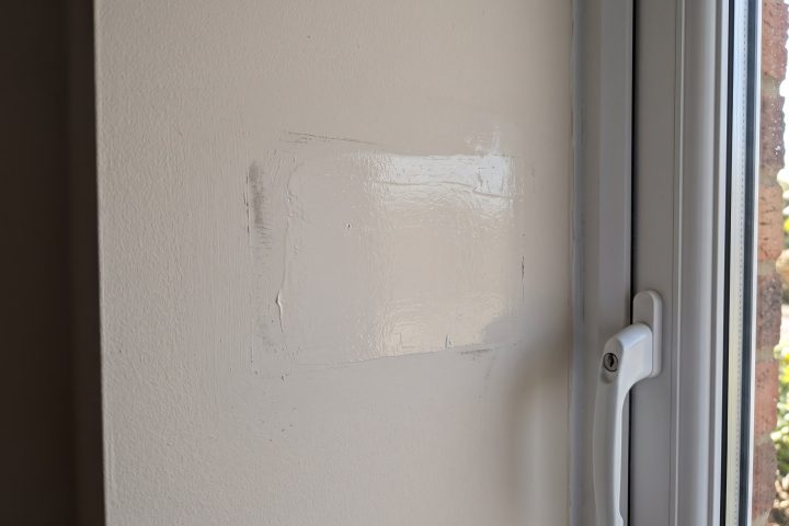 A filled and repainted patch that does not match the wall