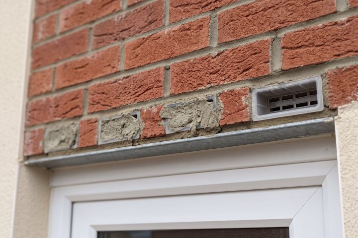 Three mortar-blocked weep holes next to one clear one