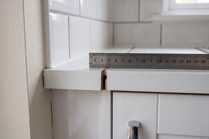Kitchen worktop joint open with a steel rule for scale